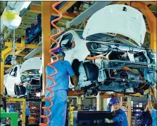  ?? DUAN CHANGZHENG / FOR CHINA DAILY ?? Employees assemble a new energy vehicle at an auto plant in Jiangxi province.