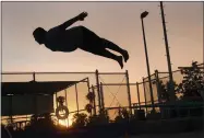  ??  ?? Josue Meza, 15, dives in from the diving board as the sun sets behind him Friday, Aug. 3, 2018 at thedive-in Theater, hosted by Portervill­e Parks and Leisure at the City Pool.