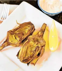  ??  ?? Artichokes halves fried in olive oil can be served with mayonnaise and wedges of fresh lemon.