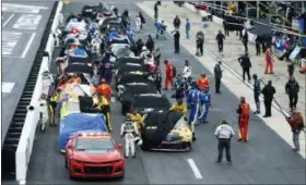  ?? WADE PAYNE — THE ASSOCIATED PRESS ?? Crews cover their cars as a rain delay is called during a NASCAR Cup Series auto race, Sunday in Bristol, Tenn.