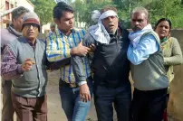  ?? AFP ?? Local residents escort an injured bus passenger after the accident in Sawai Madhopur on Saturday. —