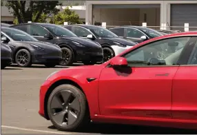  ??  ?? Electric cars are parked at a Tesla delivery location and service center in Corte Madera, Calif.