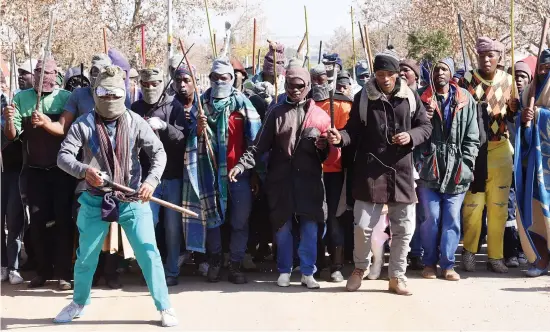  ?? Picture: Nigel Sibanda ?? MASKED THREATS. Workers in Randjesfon­tein protest for a wage hike outside the gates of the North Rand Training Centre in Midrand.