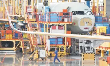  ??  ?? This file photoshows a worker walking past planes under constructi­on at the Airbus A320 Family Final Assembly Line, after the inaugurati­on ceremony of the Airbus A330 Completion and Delivery Centre in Tianjin. China has ordered 184 Airbus A320 planes...