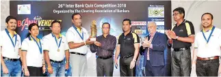  ??  ?? HNB ‘A’ team captain receives winner’s trophy from main sponsor and chief guest Bank of Ceylon General Manager and CEO Senarath Bandara in the presence of CAB President M. Razak Deen, Quiz Master Ravi Molligoda and CAB Secretary Janak Palugaswew­a