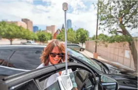 ?? PHOTOS BY NATHAN J. FISH/THE OKLAHOMAN ?? Liz Bowman places an air quality monitor on her car Aug. 12 as she and Councilwom­an JoBeth Hamon prepare to ride a route through Oklahoma City and collect environmen­tal data during an “urban heat island” mapping campaign for the city.