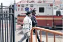  ?? AFP ?? People walk by a hospital in a neighborho­od among those that have seen some of the highest number of city Covid-19 deaths in the Queens borough of New York City.