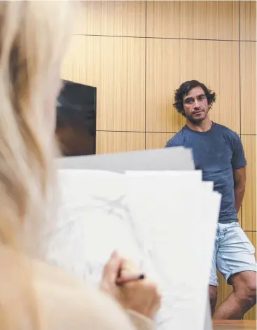  ??  ?? SITTING QUIETLY: Local Cairns artist Kristin Tennyson undertakes a preliminar­y sketch for a portrait of Johnathan Thurston to enter in this year's Archibald Prize.