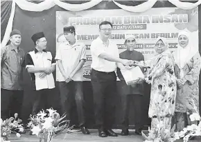  ??  ?? TAHNIAH: Lo (tengah) menyampaik­an hadiah kepada salah seorang peserta program yang dijalankan di Kuching kelmarin.