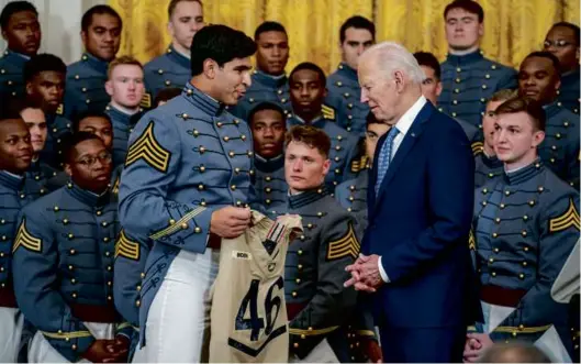  ?? AnDREw haRnIk/gEttY ImagES ?? GRIDIRON GLORY — Jimmy Ciarlo, captain of the west Point military academy football team, presented President Biden with an army Black knights jersey during a ceremony in the white house monday honoring the Black knights. as the top military football team, army won the annual Commander-in-Chief’s trophy.