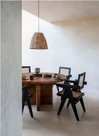  ??  ?? Dining room ‘Capitol Complex’ chairs, a Pierre Jeanneret design, reissued in 2019 by Cassina, surround a table from Terreo Studio’s shop in La Valeta. The pottery on the table was handmade in Oaxaca
Kitchen Another Terreo Studio design, the island was crafted from locally sourced timber, with black granite used for the worktop. For similar bar stools try Cox & Cox Living room Church-like arched steel windows frame the surroundin­g jungle. The chairs are the ‘Kangaroo’ design by Pierre Jeanneret, recently reissued by Cassina, while the rug and sofa are from Terreo Studio. For similar oversized wicker lampshades, try Tine K Home