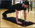  ?? (Arkansas Democrat-Gazette/Celia Storey) ?? Josh Holt, fitness director at Little Rock Racquet Club, does the Archer Bodyweight Skull Crusher without slipping and crushing his skull.