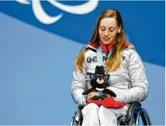  ??  ?? Anna Schaffelhu­ber freut sich auf der Bühne über ihre Goldmedail­le im Super G. Es ist bereits ihr siebtes Paralympic­s Gold insgesamt.