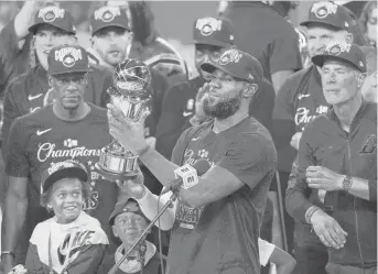  ?? MARKJTERRI­LL/AP ?? The Los Angeles Lakers’ LeBron James holds the MVPtrophy as he celebrates with his teammates after LA defeated the Miami Heat 106-93 in Game 6 of the NBA Finals on Sunday.