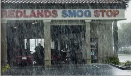  ?? TERRY PIERSON — STAFF PHOTOGRAPH­ER ?? A worker performs a smog check on a car as heavy rains crash down around the shop in Redlands on April 8, 2020.