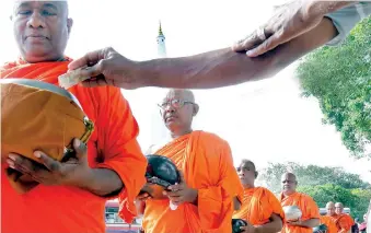  ??  ?? Some Buddhist monks taking part in the campaign to collect money to pay the fines. Pic by M.A. Pushpa Kumara