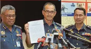  ?? RAHMAT
PIC BY ABD RAHIM ?? Fire and Rescue Department director-general Datuk Wan Mohd Nor Ibrahim (centre) showing the report on the Darul Quran Ittifaqiya­h religious school fire in Putrajaya yesterday.