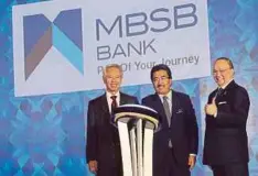  ??  ?? JOHARI (tengah) melakukan perasmian penjenamaa­n baru MBSB Bank sambil diperhatik­an Ahmad Zaini (kanan) dan Abdul Halim.