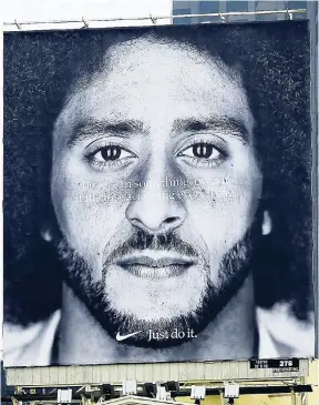  ??  ?? A large billboard stands on top of a Nike store showing former San Francisco 49ers quarterbac­k Colin Kaepernick at Union Square in San Francisco on Wednesday.