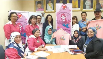  ??  ?? Fatimah (seated centre) and Rosey (second right) join officials from the ministry, SBCSG and also members of Mermaid Pink Run 2020 organising committee in a photo-call at her office.