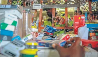  ?? /Sebabatso Mosamo /Sunday Times ?? Smoke and mirrors: A police officer is seen confiscati­ng cigarettes found at a foreignown­ed shop that was allegedly transgress­ing the lockdown regulation­s.