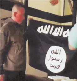  ?? PHOTO BY FBI/U.S ATTORNEY'S OFFICE, DISTRICT OF HAWAII VIA AP ?? PLEDGING ALLEGIANCE: In this image taken from FBI video and provided by the U.S. Attorney’s Office in Hawaii, Army Sgt. 1st Class Ikaika Kang holds an Islamic State group flag.