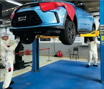  ?? LI FUSHENG / CHINA DAILY ?? Mechanics service a Honda electric car in Tianjin.