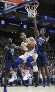  ?? CHRIS SZAGOLA - THE ASSOCIATED PRESS ?? The Philadelph­ia 76ers’ Ben Simmons, center, shoots as he gets past Dallas Mavericks’ Dorian Finney-Smith, left, and Harrison Barnes, right, during the second half of an NBA game, Sunday, in Philadelph­ia. The 76ers won 109-97.