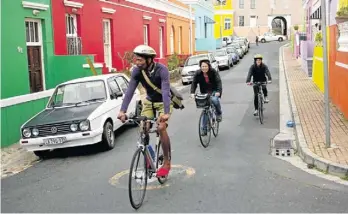  ??  ?? COLOUR WHEEL: Guide Skeezo Vicani, Claire and Angela Mittermair from Germany ride through the Bo-Kaap