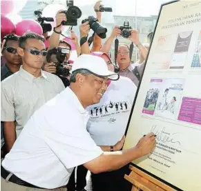  ??  ?? Let the celebratio­n begin: Muhyiddin signing the World Kidney Day celebratio­ns plaque at Dataran Merdeka in Kuala Lumpur yesterday. — Bernama