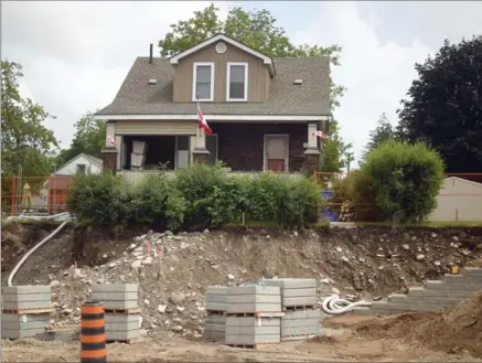  ?? DAVID BEBEE, RECORD STAFF ?? This Preston home at 329 King St. E. sits on the edge of road widening constructi­on as a retaining wall is being built.
