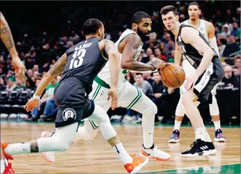  ?? (AP Photo/Charles Krupa) ?? Boston Celtics guard Kyrie Irving, center, drives between Brooklyn Nets guard Shabazz Napier (13) and forward Rodions Kurucs (00) during the second half of an NBA basketball game in Boston, Monday, Jan. 7, 2019.