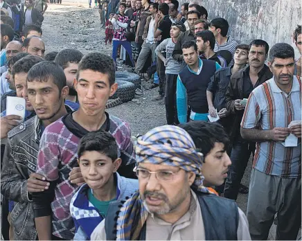  ?? Picture / AP ?? Residents queue for aid packages in Gogjali, on the eastern edge of Mosul, after Isis fighters were pushed out of the eastern edge of the city.