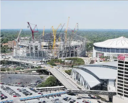  ?? DAVID GOLDMAN/THE ASSOCIATED PRESS FILES ?? Mercedes-Benz Stadium, the future home of the Atlanta Falcons football team, stands under constructi­on in May, next to the team’s current stadium, the Georgia Dome. Problems with the stadium could be behind Canam Group Inc.’s second-quarter loss.