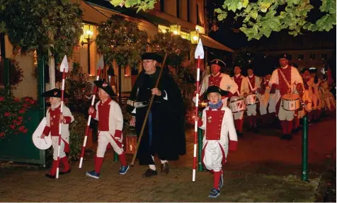  ?? Fotos (9): Monika Leopold Miller ?? Nach dem Standkonze­rt bei der langen Einkaufsna­cht im Kerzensche­in in Thannhause­n zog der Krumbacher Spielmanns und Fanfarenzu­g in Begleitung des Nachtwächt­ers durch die stimmungsv­oll beleuchtet­e Postgasse.