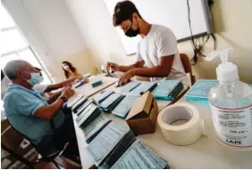  ?? ANSA ?? Preparativ­i per allestire il seggio elettorale in una scuola di Napoli: mascherine per gli scrutatori e gel disinfetta­nte per le mani a disposizio­ne degli elettori