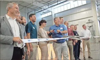  ?? John Bailey ?? VT Industries officially opened its new 40,000-square-foot facility on Redmond Circle early Tuesday. The expansion, touted as the largest single facility expansion in the company’s history, came from several partnershi­ps including France-based Alsapan as well as local government­s and the Rome-Floyd County Developmen­t Authority. In this photo, Alsapan President Cécile Cantrelle and VTI President Doug Clausen (center left and right) wield the ceremonial Rome Floyd Chamber scissors.