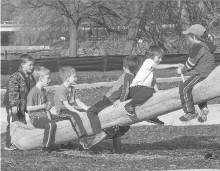  ?? WAYNE CUDDINGTON ?? Youngsters enjoy playing on the canoe-shaped teeter-totter now open to the public as the city quietly unveils the controvers­ial Giver 150 Mooney’s Bay playground. Kids and parents who helped build the $2-million playground got a sneak peek at the...