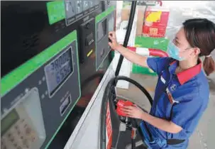  ?? SONG JIE / XINHUA ?? An employee of a gas station in Xingtai, Hebei province, operates a fuel filling facility.