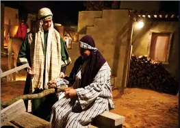  ?? SUBMITTED ?? Don Stair, standing, watches as Billy Marsh cuts wood at one of the storefront­s as part of last year’s Living Nativity at Searcy First Assembly of God.