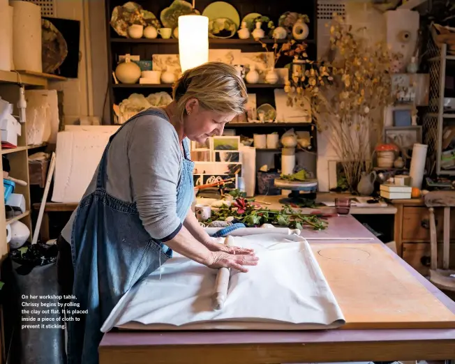  ??  ?? On her workshop table, Chrissy begins by rolling the clay out flat. It is placed inside a piece of cloth to prevent it sticking.