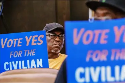  ?? Steph Chambers/ Post- Gazette ?? Khalid Raheem, of the North Side, an organizer with the Committee for a Civilian Police Review Board of Allegheny County, holds a sign during a County Council meeting Wednesday at the county courthouse.