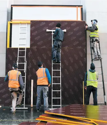  ?? PHOTO AFP ?? Plusieurs personnes s’affairaien­t, hier, sur les Champs-élysées, à barricader les vitres des commerces en prévision des manifestat­ions prévues aujourd’hui à Paris.