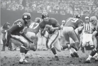  ?? AP FILE ?? In this 1964 photo, New York Giants quarterbac­k Y.A. Tittle, rolls out during a game against the Cleveland Browns at Yankee Stadium.