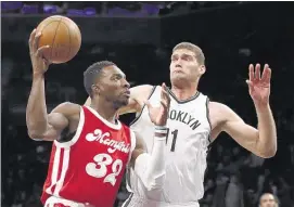  ?? KATHY WILLENS / ASSOCIATED PRESS ?? Grizzlies for ward Jef f Green, who scored 18 point s of f the bench, drives around Brooklyn Net s center Brook Lopez during the first half Wednesday night in New York.