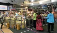  ??  ?? Competitor­s gather around the field during the first day of competitio­n Friday in the New York Tech Valley Regional FIRST Robotics Competitio­n in the East Campus Village Arena at Rensselaer Polytechni­c Institute.