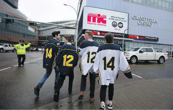  ?? DAVID BLOOM ?? Young hockey players head into a public memorial for Edmonton-area Humboldt Broncos players Jaxon Joseph, Logan Hunter, Parker Tobin and Stephen Wack at Rogers Place.