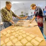  ??  ?? Carl Levan of Ruscombman­or Township, left and Henry Schlegel of Oley Township cut dough into rectangula­r pieces Saturday at Friedens United Church of Church in Oley. Church members were make fasnachts for Fat Tuesday.