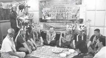  ??  ?? Club member Kembuan Thomas (standing second left) performs the bebiau ceremony. Aaron is seated at centre.