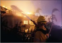  ?? ?? A firefighte­r works to put at a structure burning during a wildfire Wednesday, May 11, 2022, in Laguna Niguel.